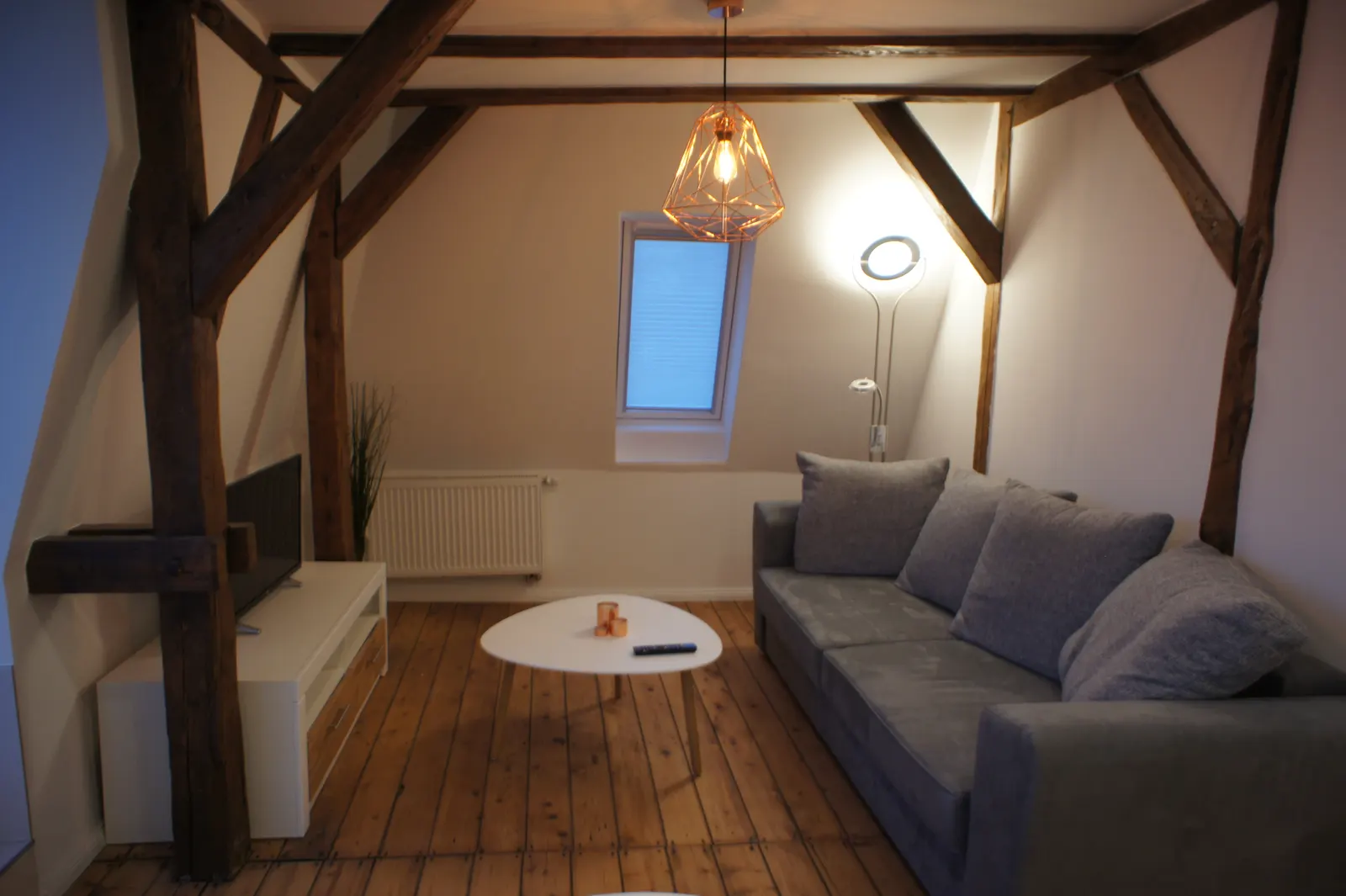 Wohnbereich der Dachgeschosswohnung mit historischem Gebälk